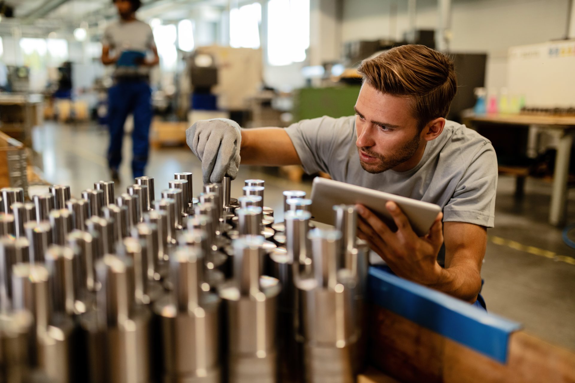 Young worker performing quality control of manufactured products in a warehouse.